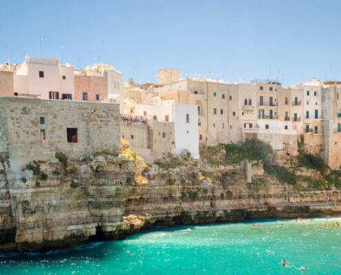 Buildings of Puglia on cliff looking over turquoise water