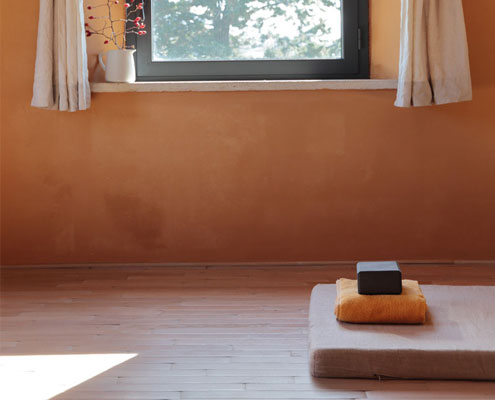Room with yoga mat and light shining in through window.